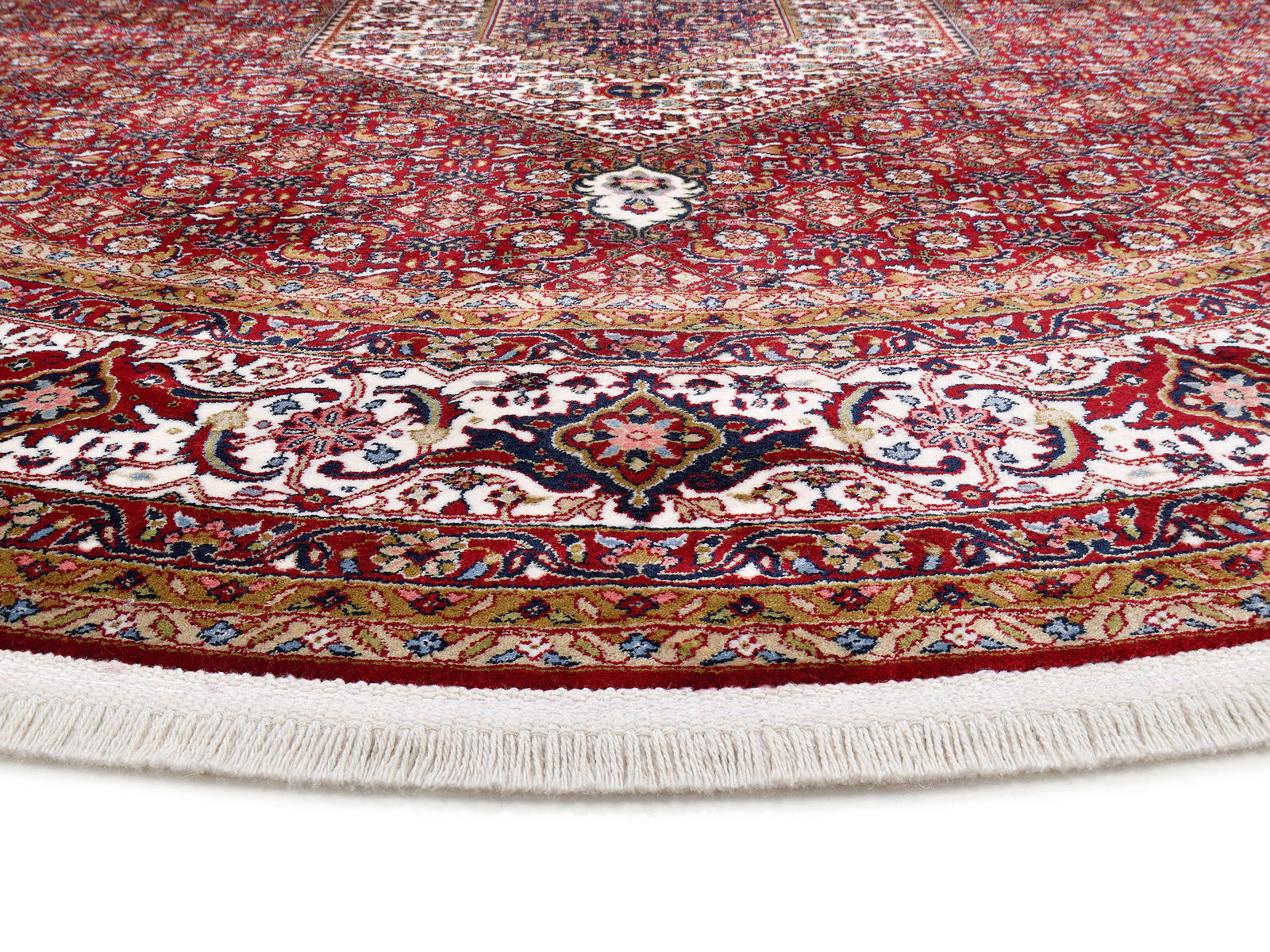 Nahaufnahme eines orientalischen Teppichs mit reichhaltigem, detailliertem Muster in Rot-, Weiß- und Blautönen, perspektivisch von der Seite aufgenommen.