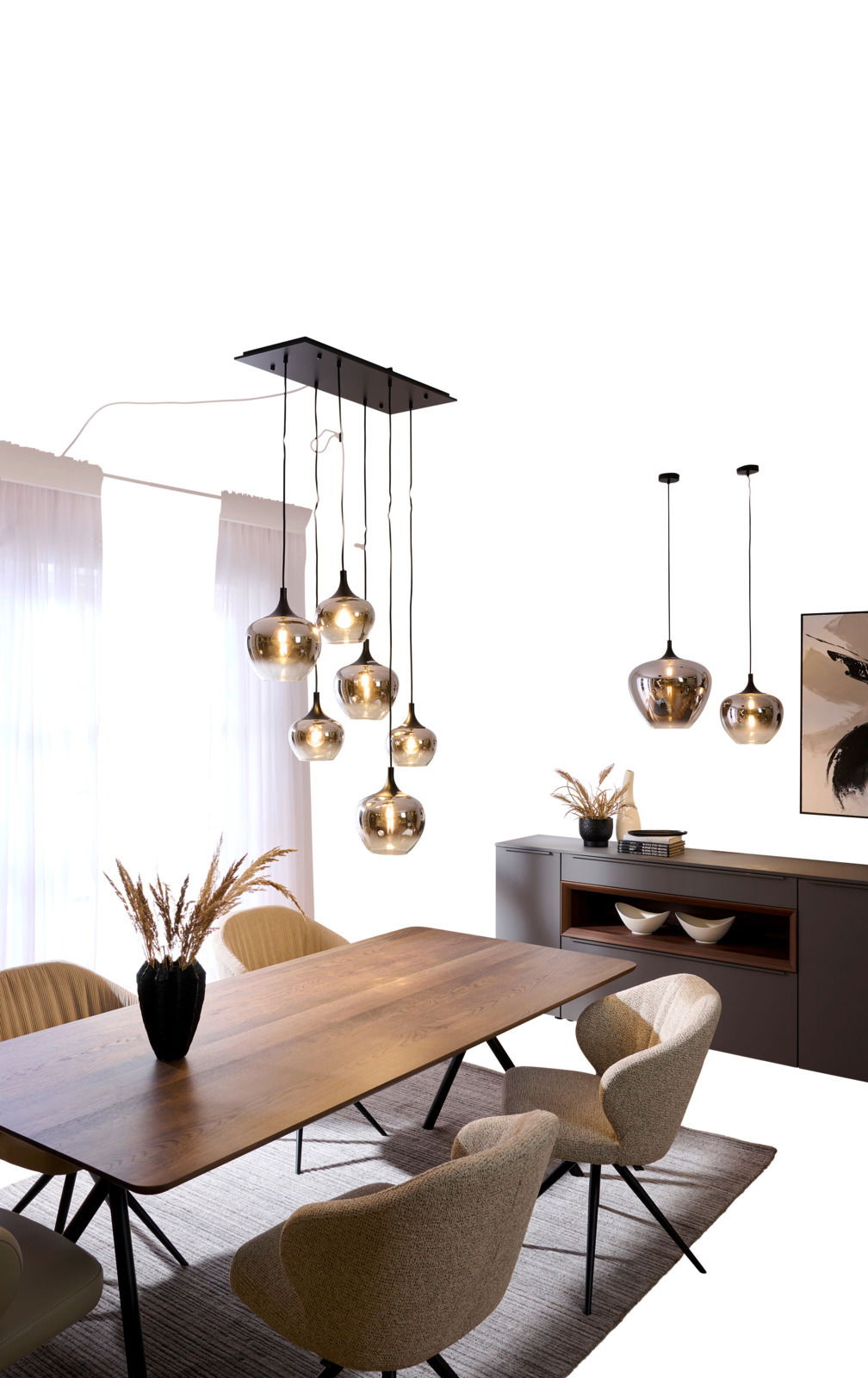 Moderne Hängeleuchte mit mehreren Glaskugeln, von der Decke hängend über einem Esstisch, seitliche Perspektive.