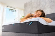 Frau liegt entspannt auf einer Viscomatratze in einem hellen Raum, seitliche Perspektive.