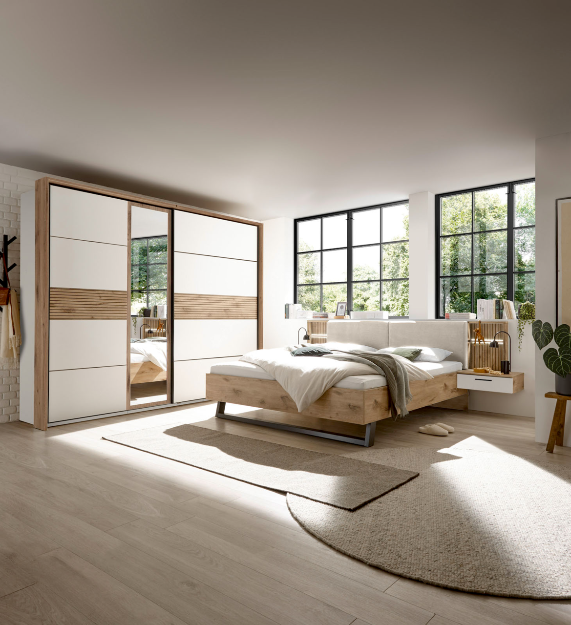 Modernes Schlafzimmer mit Schwebetürenschrank und Bettanlage in heller, natürlicher Holzoptik, seitliche Perspektive