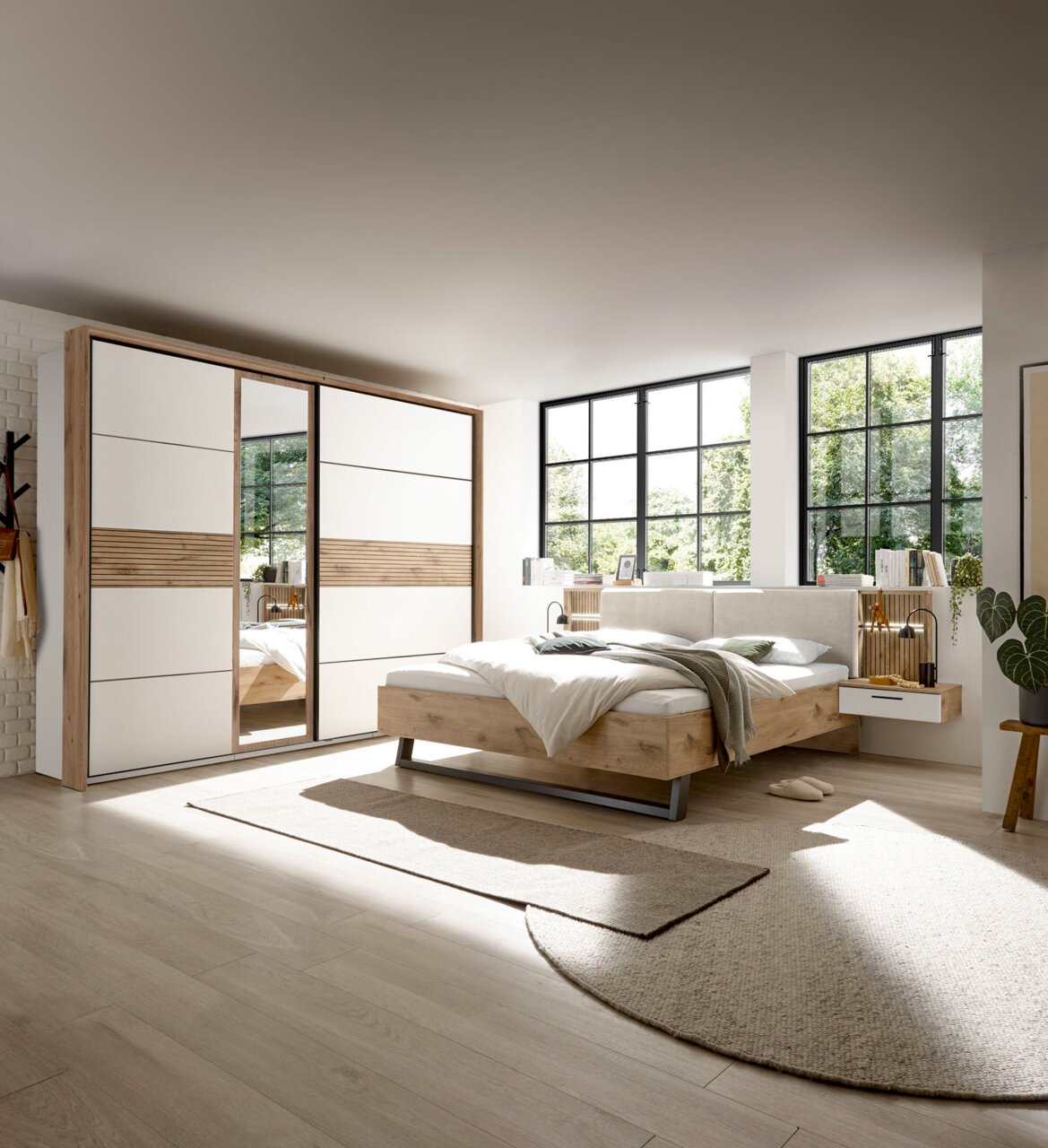 Modernes Schlafzimmer mit Schwebetürenschrank und Bettanlage in heller, natürlicher Holzoptik, seitliche Perspektive