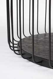 Nahaufnahme eines modernen Couchtischs mit schwarzem Metallgestell und runder Holzplatte, seitliche Perspektive