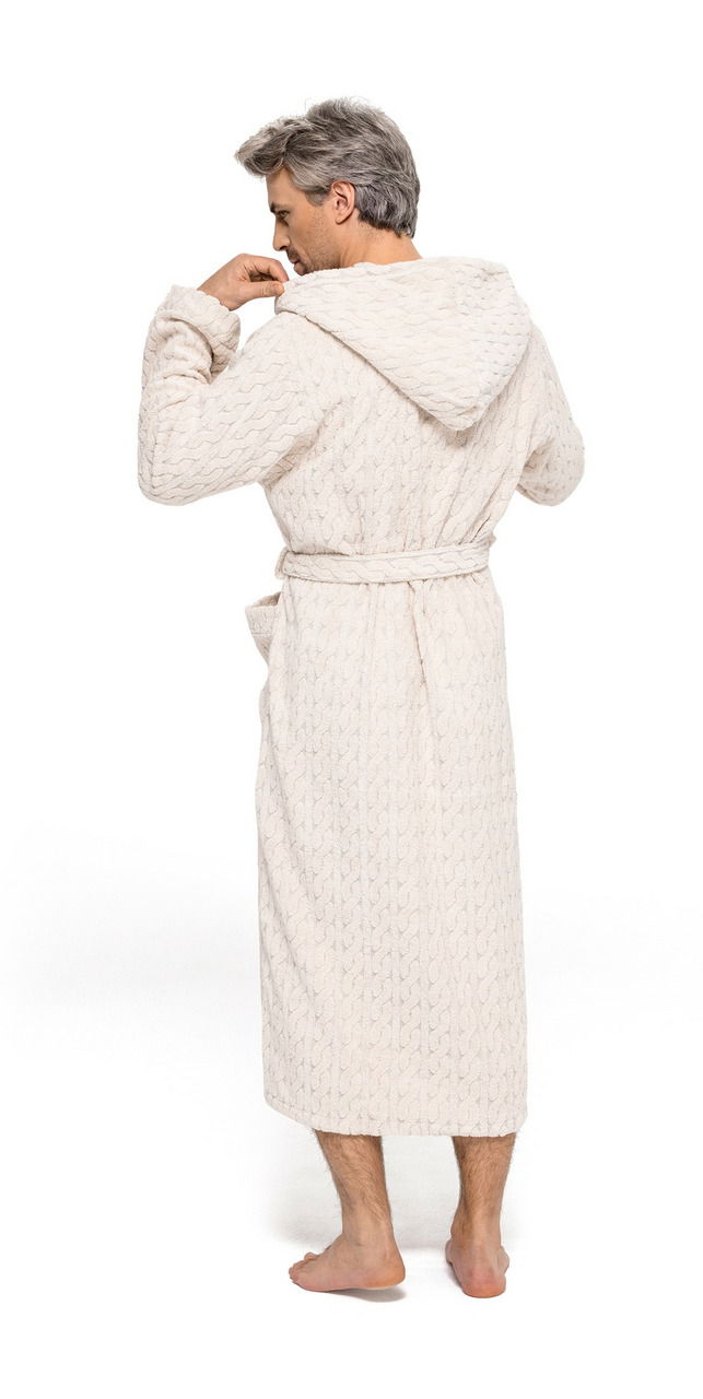 Rückansicht eines Mannes in einem cremefarbenen Kapuzenmantel aus Strickstoff, barfuß stehend.