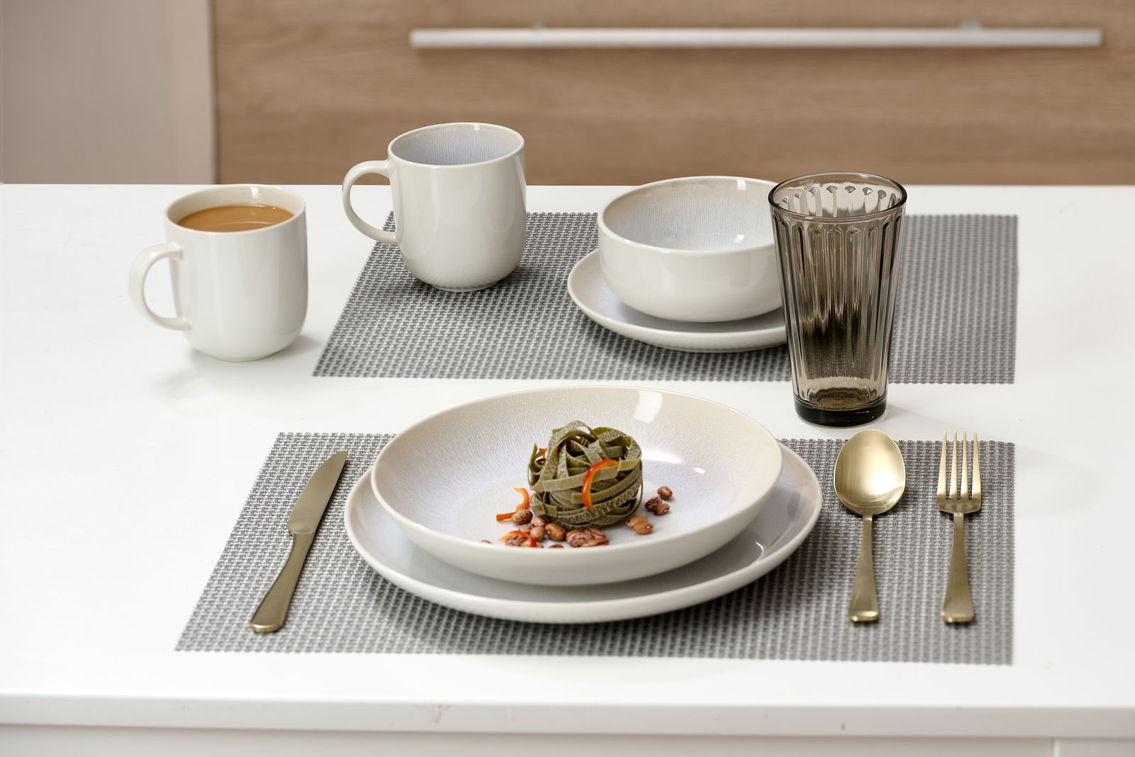 Dessertteller Laredo 20,5cm auf einem gedeckten Tisch mit Besteck, Tassen und Glas, aus der Vogelperspektive fotografiert.