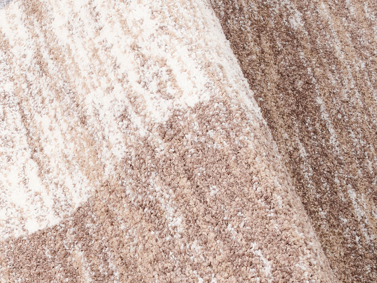 Nahaufnahme eines Frisé-Teppichs in Beige- und Brauntönen, schräg von der Seite fotografiert.