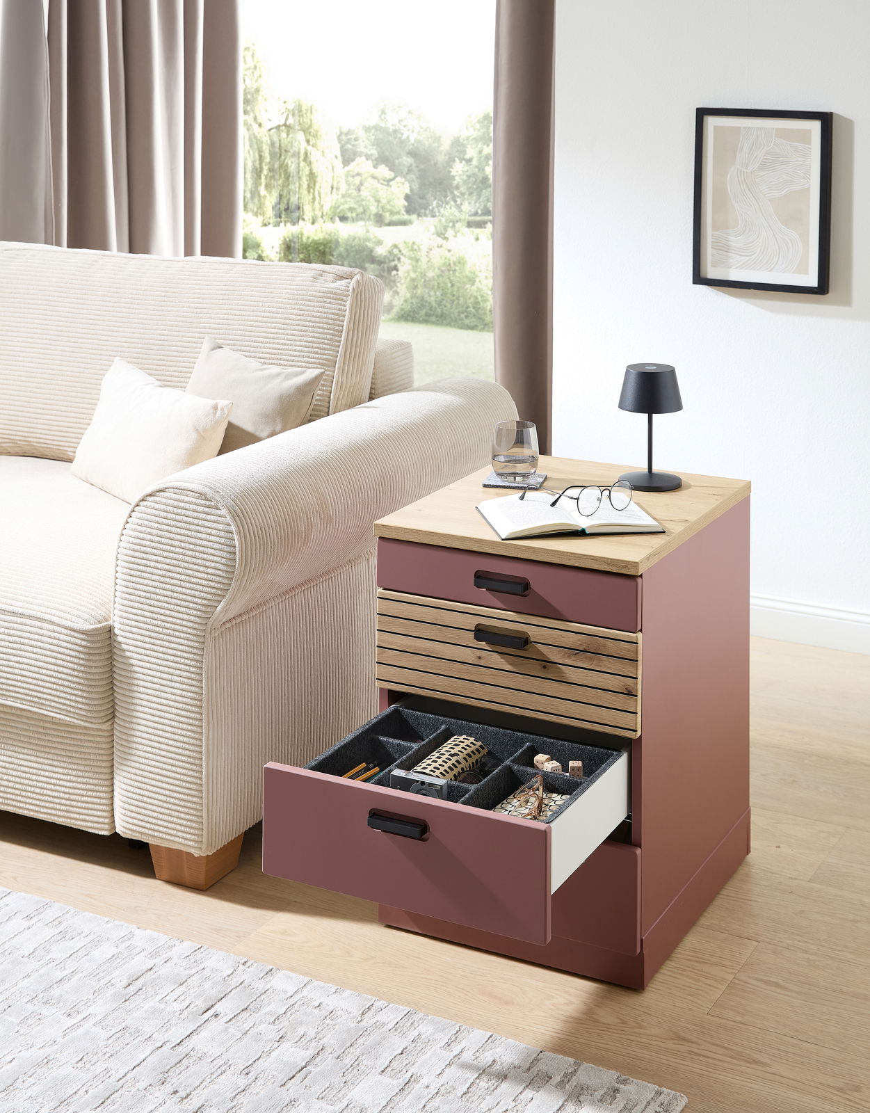 Rollcontainer in moderner Wohnzimmerumgebung, seitliche Perspektive, mit geöffneter Schublade zur Aufbewahrung von Schmuck und Accessoires.