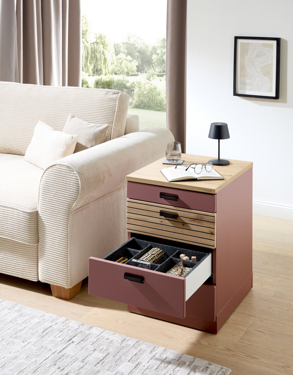 Rollcontainer in moderner Wohnzimmerumgebung, seitliche Perspektive, mit geöffneter Schublade zur Aufbewahrung von Schmuck und Accessoires.