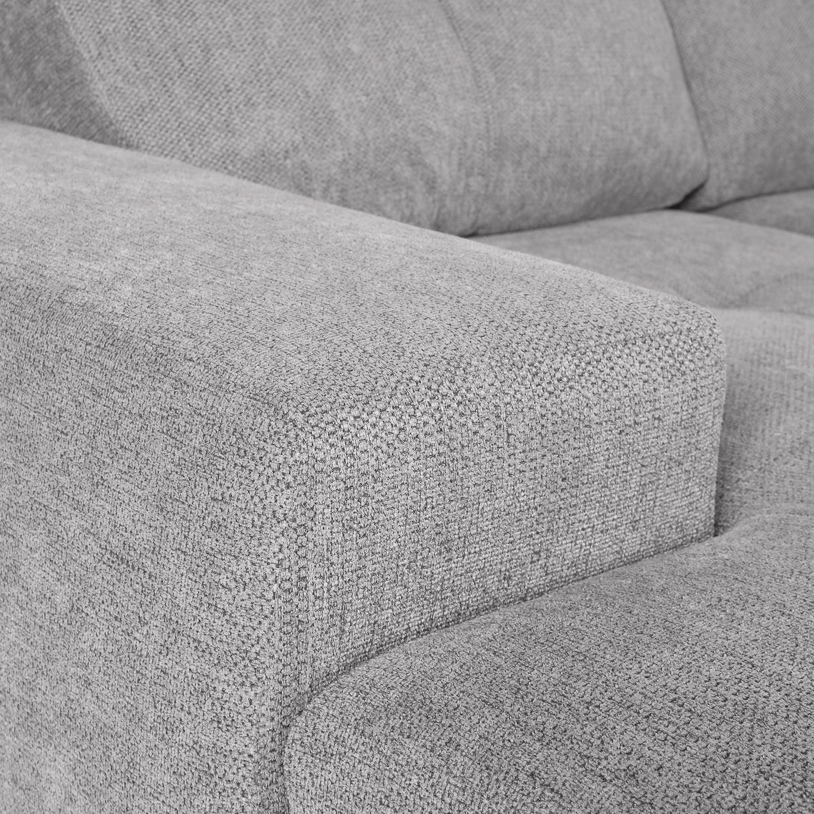 Nahaufnahme einer grauen Stoff-Rundecke mit Armlehne, Perspektive von der Seite.