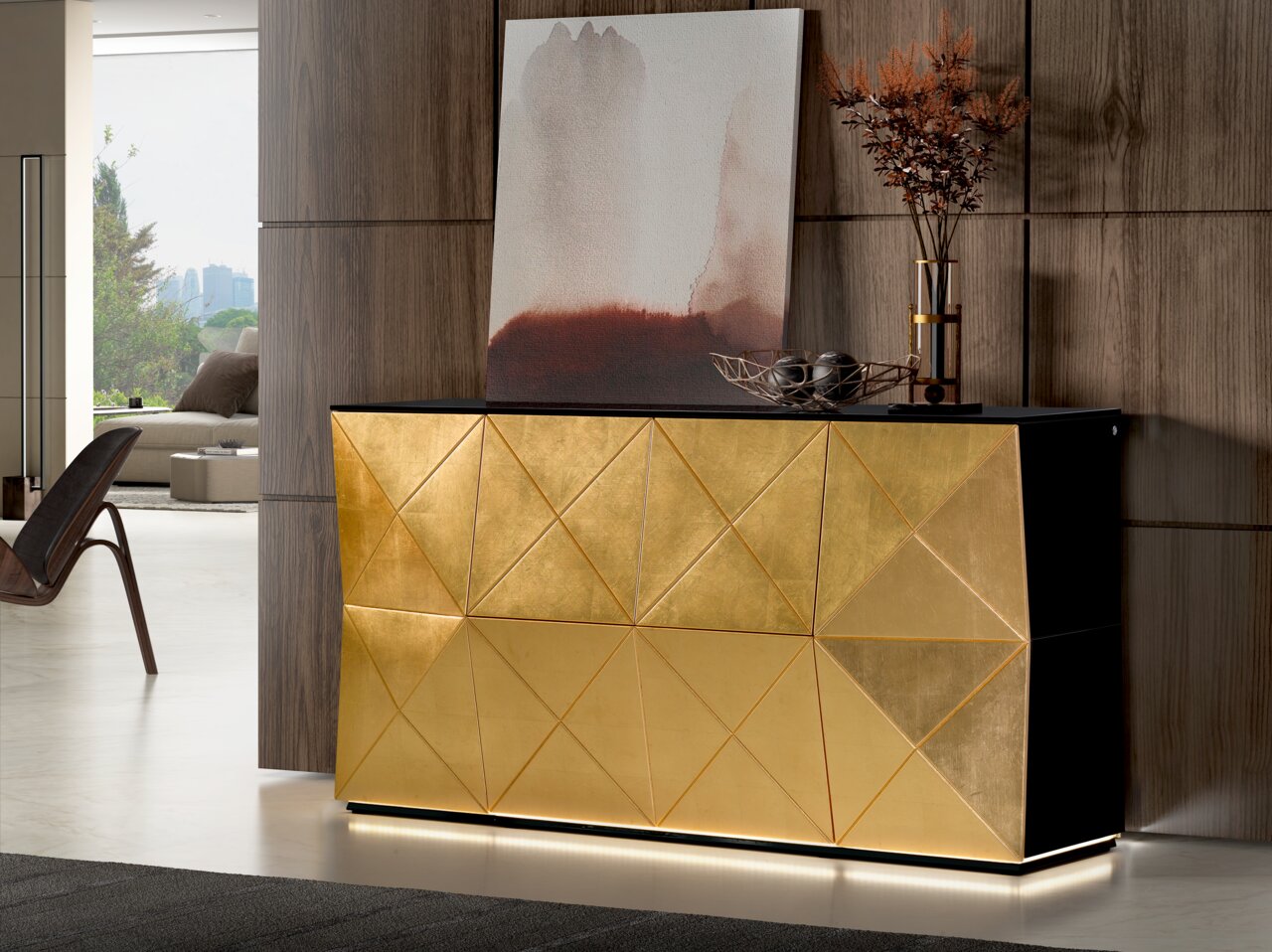 Ambiente Sideboard RUBY PLUS Goldenes Sideboard mit geometrischem Muster, seitliche Perspektive, dekoriert mit Kunstwerk und Vase.