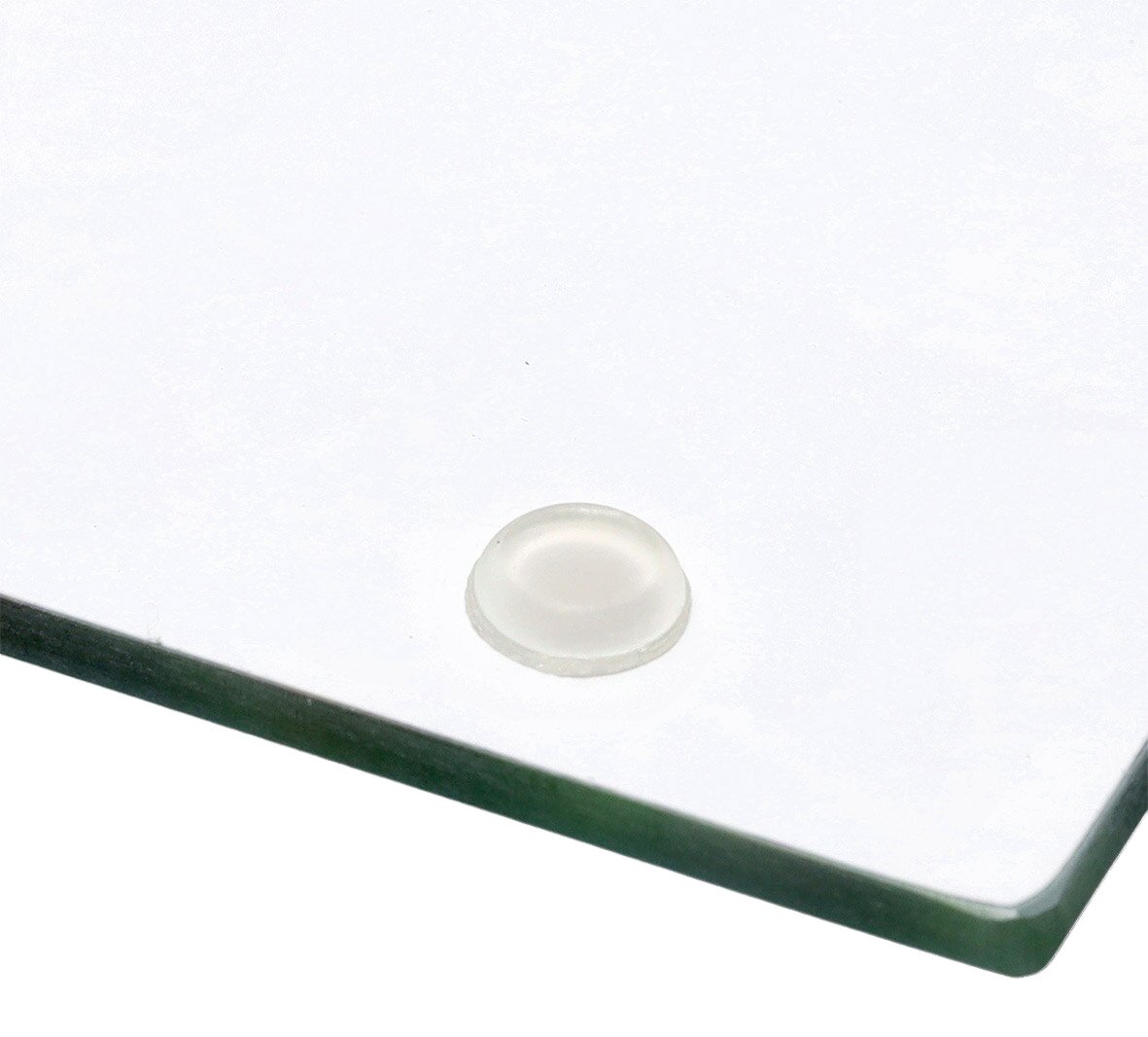 Nahaufnahme einer transparenten Herdblende-Abdeckplatte mit Gummifüßen.