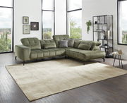 Grüne Eckgarnitur in modernem Wohnzimmer mit großen Fenstern, seitliche Perspektive