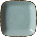 Vogelperspektive auf einen quadratischen, blauen Suppenteller mit gesprenkeltem Design und rustikalem Rand.