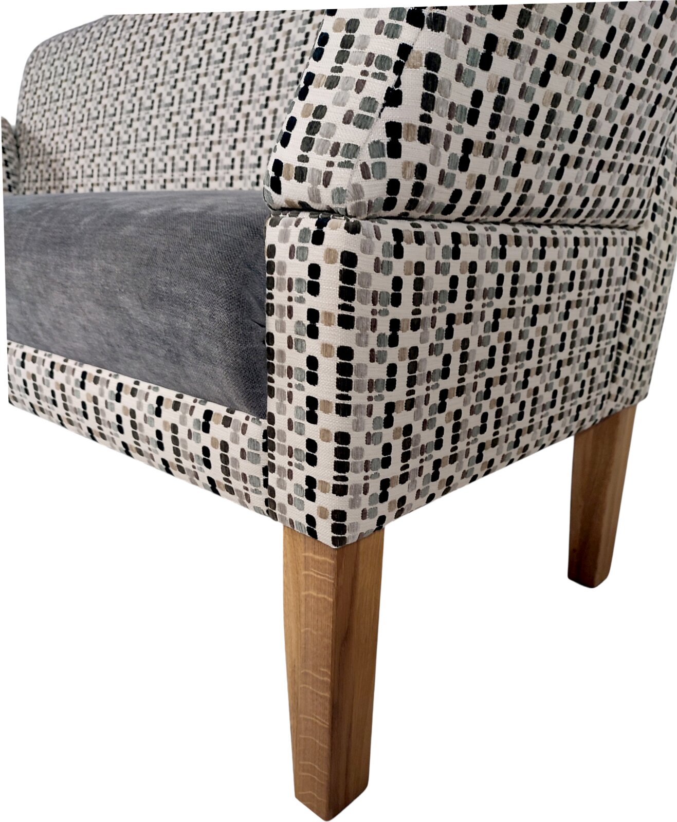 Detailansicht schräg von vorne auf einen gepolsterten Sessel mit gemustertem Stoffbezug in Grau/Beige/Schwarz, grauem Sitzkissen und Holzbeinen