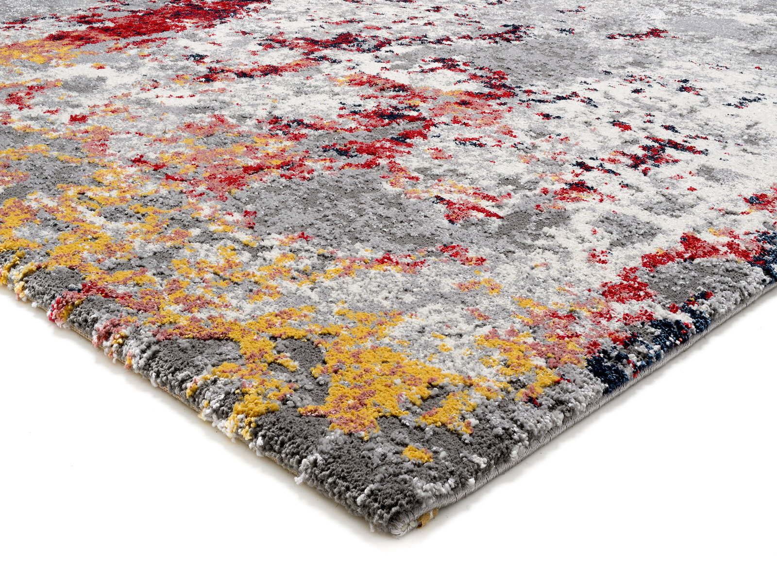 Designer Teppich mit abstraktem Muster in Grau, Rot und Gelb, aus seitlicher Perspektive fotografiert.