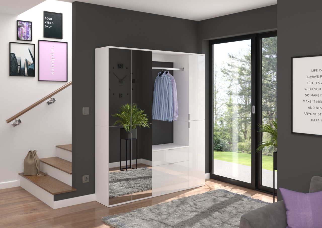 MID.YOU Garderobenkombination PROJEKT X Moderne Garderobenkombination in einem hellen Raum mit großen Fenstern, die einen Blick auf den Garten bieten. Die Garderobe hat eine glänzende weiße Oberfläche mit einem Spiegel und bietet Platz zum Aufhängen von Kleidung. Perspektive von vorne.