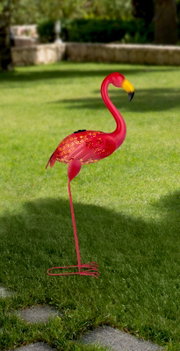 Zonne-lamp in de vorm van een roze flamingo, zijaanzicht op een grasveld