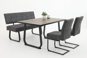 Moderner Esstisch mit dunkler Holzplatte und schwarzen Metallbeinen, umgeben von grauen Schwingstühlen und einer Bank, seitliche Perspektive.