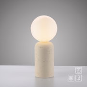 Moderne Tischleuchte mit kugelförmigem Opalglas-Schirm und zylindrischem, hellbeigem gesprenkeltem Sockel, frontal in leichter Aufsicht vor grauem Hintergrund