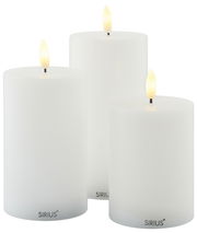 Drei weiße LED-Kerzen in verschiedenen Größen, frontal betrachtet, mit warm leuchtenden Flammen.