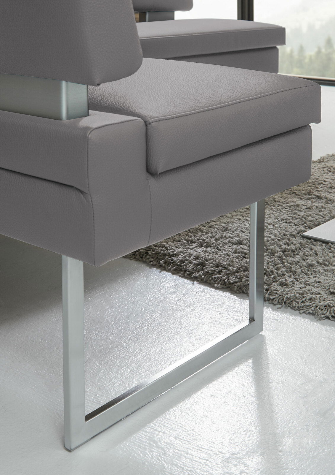 Detailansicht einer modernen grauen Eckbank mit Metallgestell und gepolstertem Sitz.