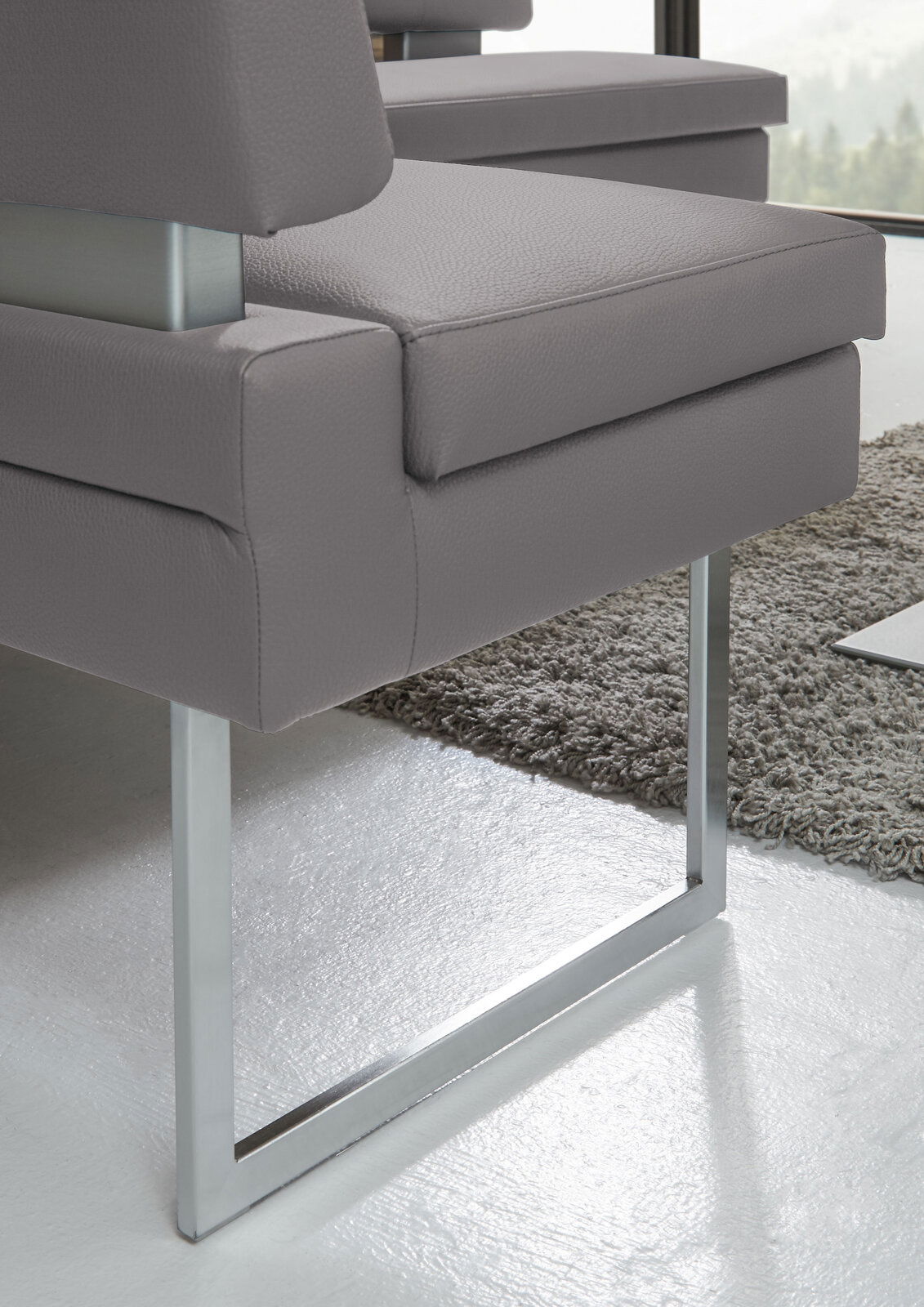 Detailansicht einer modernen grauen Eckbank mit Metallgestell und gepolstertem Sitz.