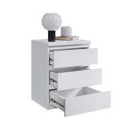 Weiße Nachtkommode mit drei offenen Schubladen, darauf eine Lampe und ein Buch, seitliche Perspektive