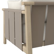 Detailfoto van een loungestoel met houten frame en beige stoffen bekleding, gezien vanaf de zijkant.
