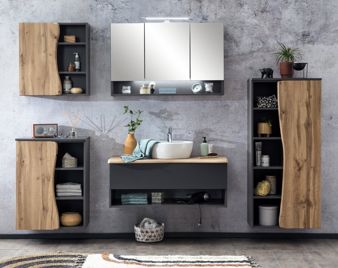 Modernes Waschtisch-Set mit Holz- und Grautönen, bestehend aus einem Waschbecken mit Unterschrank, einem Spiegel und mehreren Schränken, frontal betrachtet.