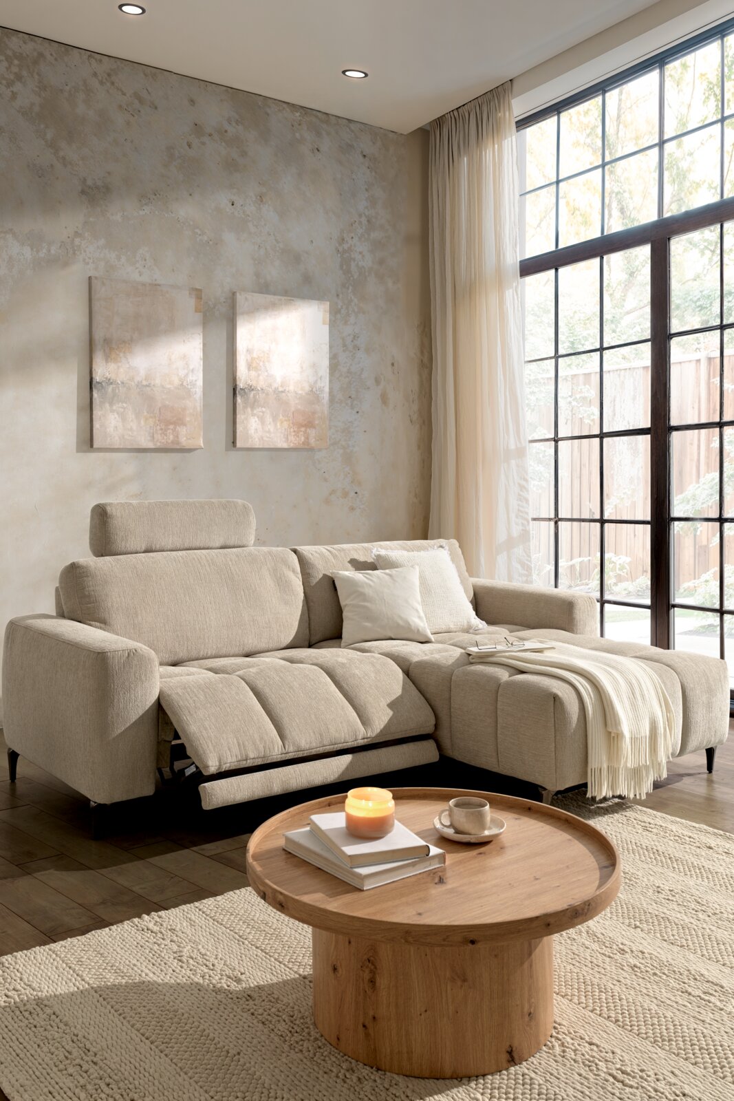Gemütliche Rundecke in einem modernen Wohnzimmer, beige Polsterung, mit verstellbarer Rückenlehne und Fußstütze, von vorne betrachtet.