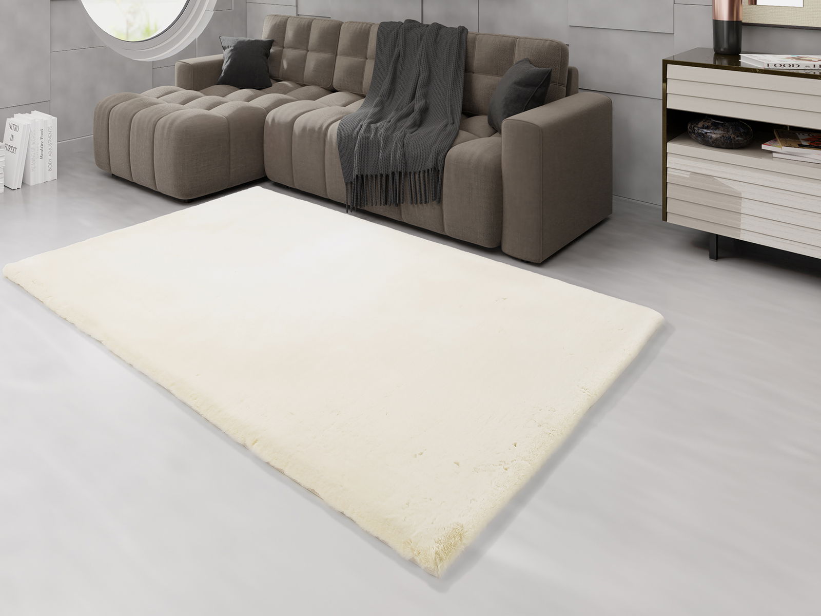 Heller Fellteppich in einem modernen Wohnzimmer, perspektivisch von oben fotografiert, mit einem grauen Sofa im Hintergrund.