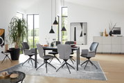 Moderne eethoek met zes grijze stoelen met armleuningen rond een zwarte tafel, een lichte en luchtige sfeer met grote ramen op de achtergrond, zijaanzicht.