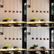 Moderne Pendelleuchte mit fünf kugelförmigen Glas-Schirmen in Rauch-/Amberoptik über einem Holztisch im Essbereich, Frontansicht auf Augenhöhe.