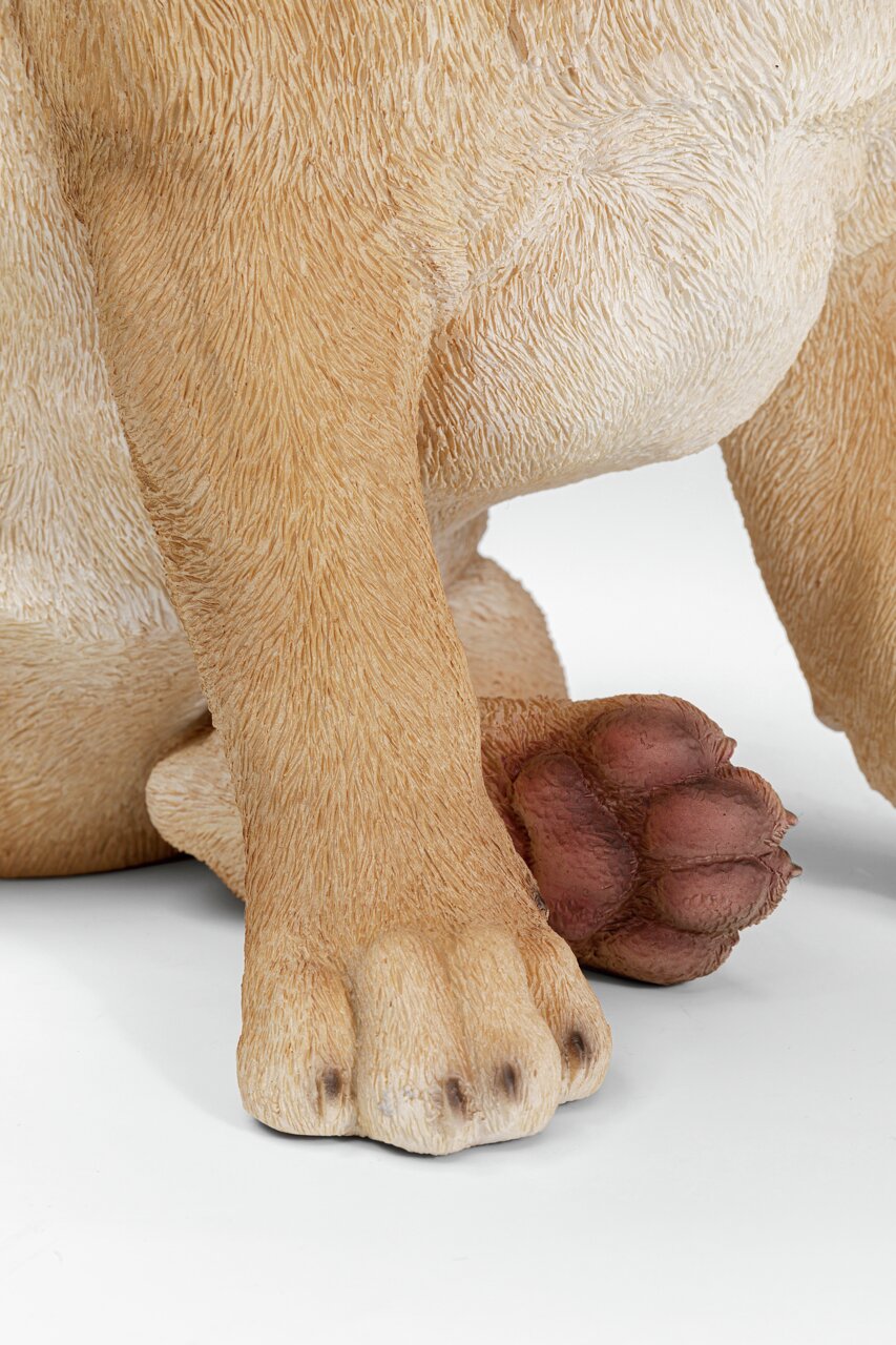 Nahaufnahme der Pfoten einer Deko-Figur eines Hundes, die detaillierte Fellstruktur und die Vorderansicht der Figur zeigend.