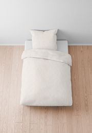 Bettwäsche-Set in Cremefarbe auf einem Bett, aus der Vogelperspektive fotografiert