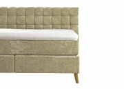 Seitliche Ansicht eines Boxspringbetts 180x200 mit gepolstertem Kopfteil und Holzfüßen.