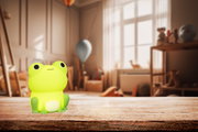 Frontalansicht eines leuchtenden, grünen Frosch-Akku-Nachtlichts auf einem Holztisch in einem gemütlichen Kinderzimmer.