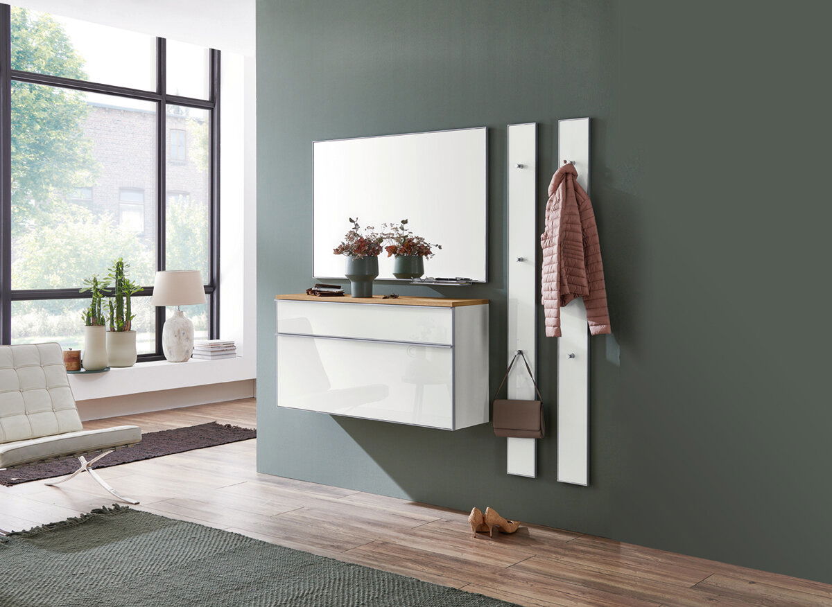 Moderner Eingangsbereich mit einem Hängeschuhschrank, einem großen Spiegel und zwei Garderobenpaneelen. Perspektive von der Seite.