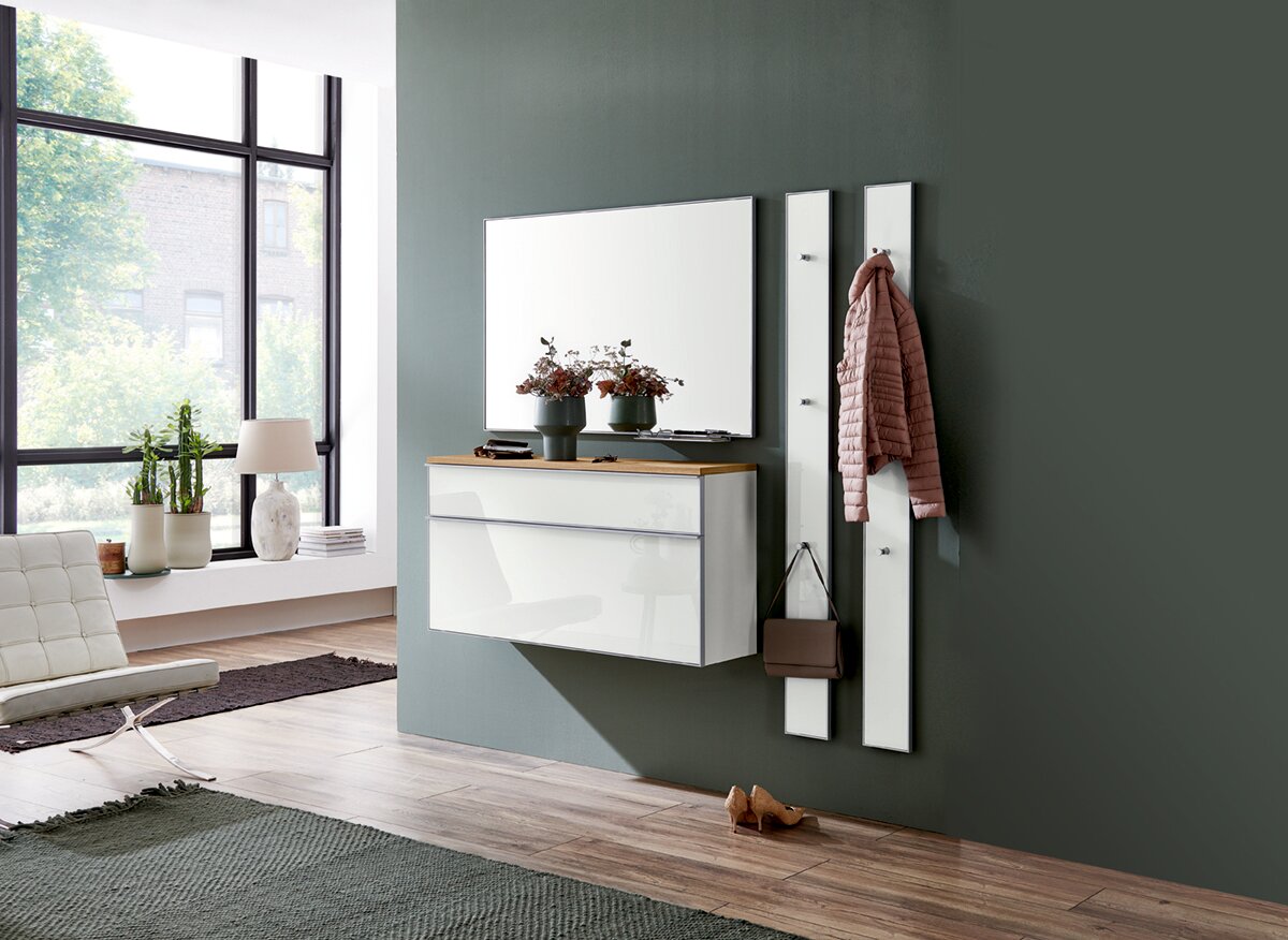 Moderner Eingangsbereich mit einem Hängeschuhschrank, einem großen Spiegel und zwei Garderobenpaneelen. Perspektive von der Seite.