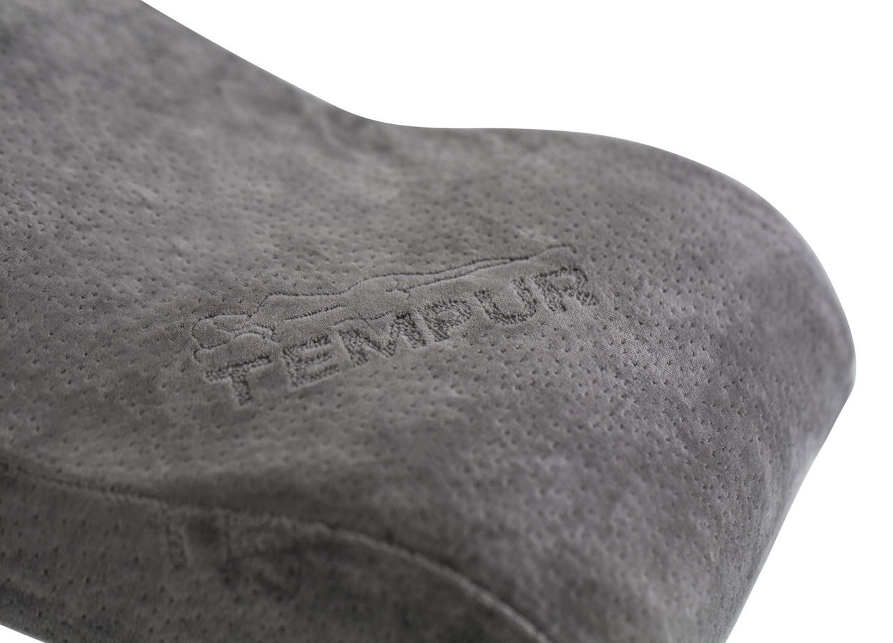 Nahaufnahme eines grauen Tempur Reisekissens mit gesticktem Logo, seitliche Perspektive