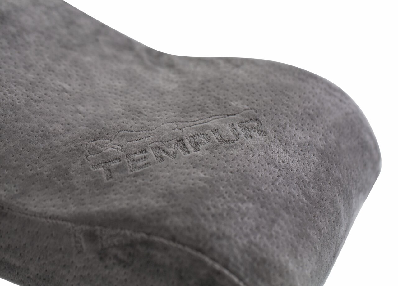 Close-up van een grijs Tempur-reiskussen met geborduurd logo, gezien vanaf de zijkant