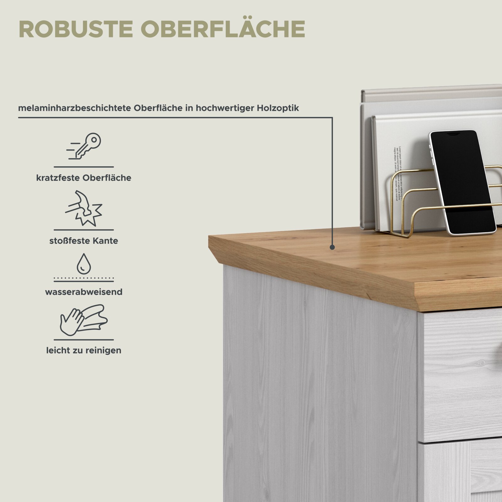 Schräg von oben fotografierte Detailansicht einer Kommode mit melaminharzbeschichteter, holzoptischer Deckplatte; zeigt robuste, kratz- und stoßfeste sowie wasserabweisende, leicht zu reinigende Oberfläche mit Smartphone und Zeitschriftenhalter.