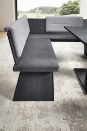 Moderne Eckbankgruppe mit grauem Stoffbezug und dunklem Holzgestell, seitliche Perspektive.