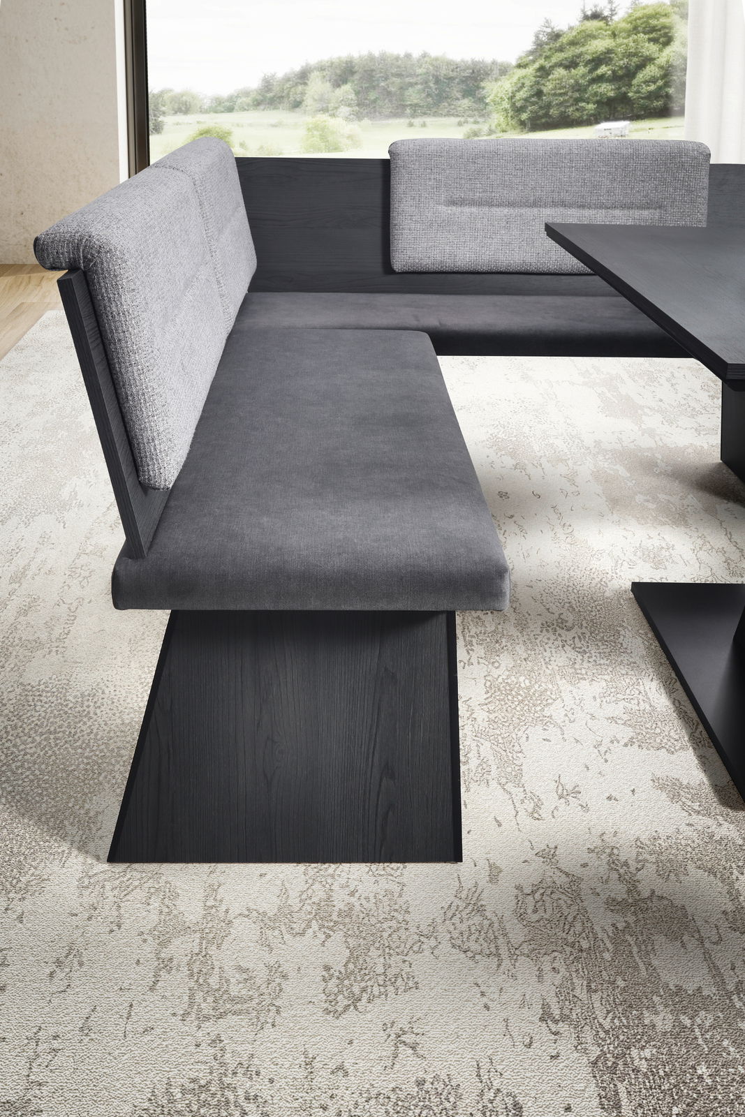 Moderne Eckbankgruppe mit grauem Stoffbezug und dunklem Holzgestell, seitliche Perspektive.