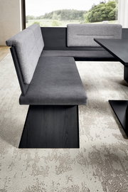 Moderne Eckbankgruppe mit grauem Stoffbezug und dunklem Holzgestell, seitliche Perspektive.
