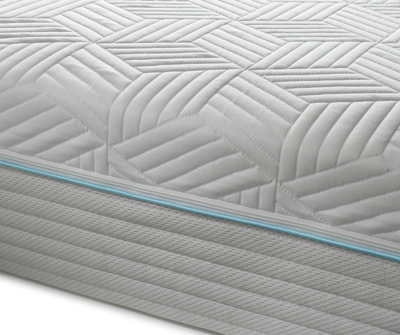 Nahaufnahme einer Gel-Taschenfederkernmatratze mit geometrischem Muster und blauer Ziernaht an der Seite.