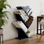 Modernes, dunkelblaues Zickzack-Bücherregal/Standregal mit schrägen Ablagen, gefüllt mit Büchern und kleinem Blumentopf, im Wohnzimmer neben einer Pflanze; Perspektive: leicht schräg von vorne.