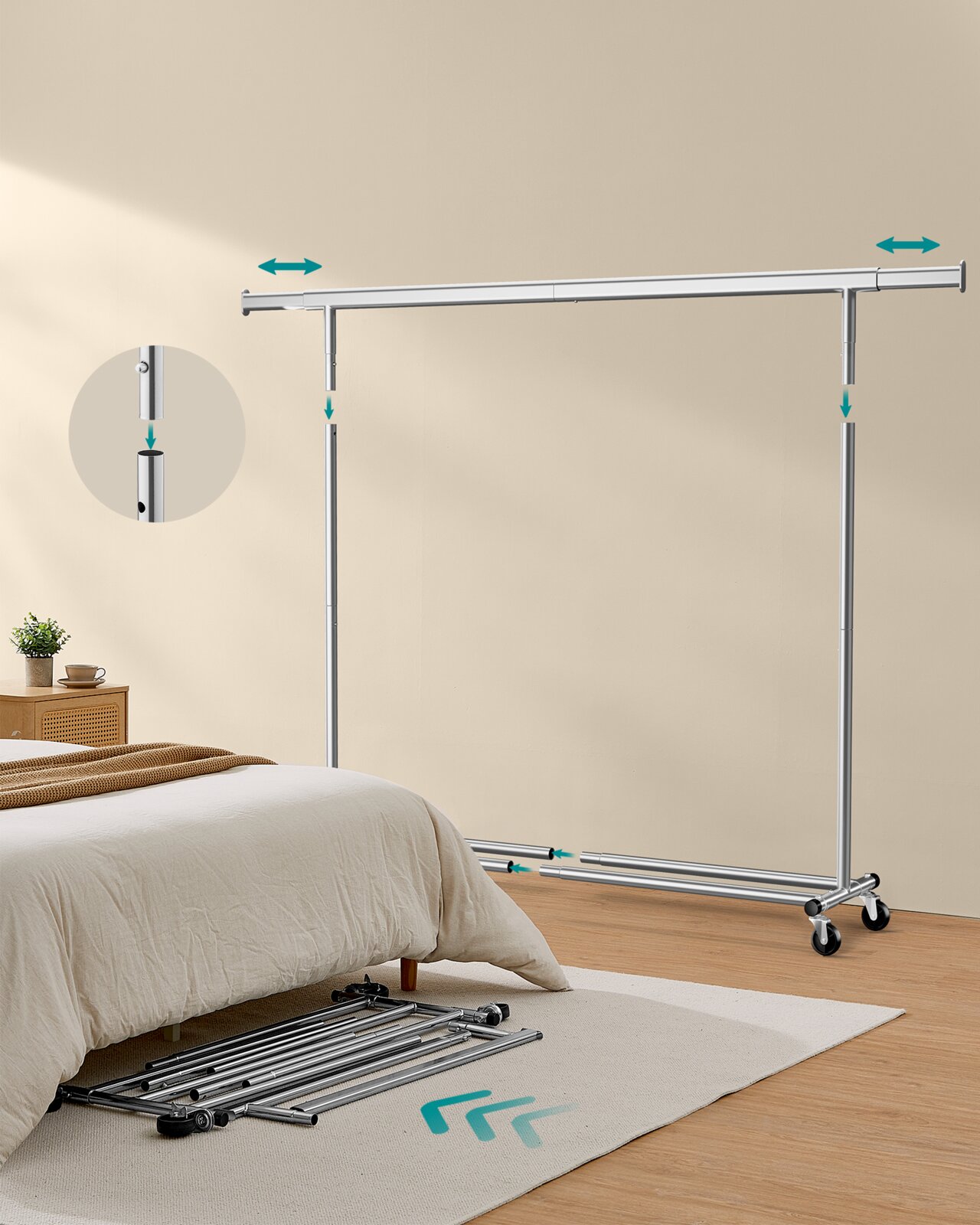 Verstellbare Kleiderstange auf Rollen aus silberfarbenem Metall mit Teleskopstange und Stecksystem, in einem Schlafzimmer neben dem Bett; Perspektive: leicht seitliche Frontalansicht.