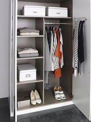 Offener Drehtürenschrank mit sechs Türen, gefüllt mit Kleidung, Schuhen und Aufbewahrungsboxen, aus der Frontalperspektive.