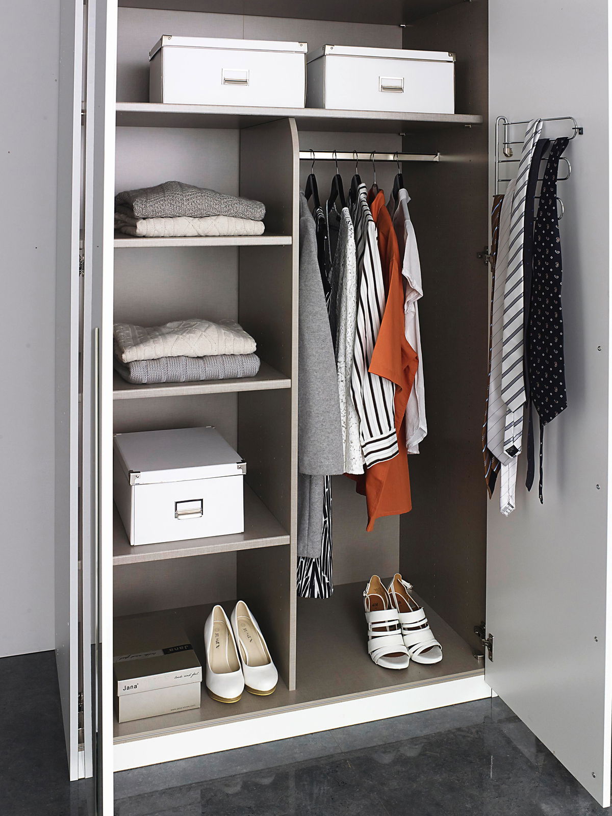 Offener Drehtürenschrank mit sechs Türen, gefüllt mit Kleidung, Schuhen und Aufbewahrungsboxen, aus der Frontalperspektive.