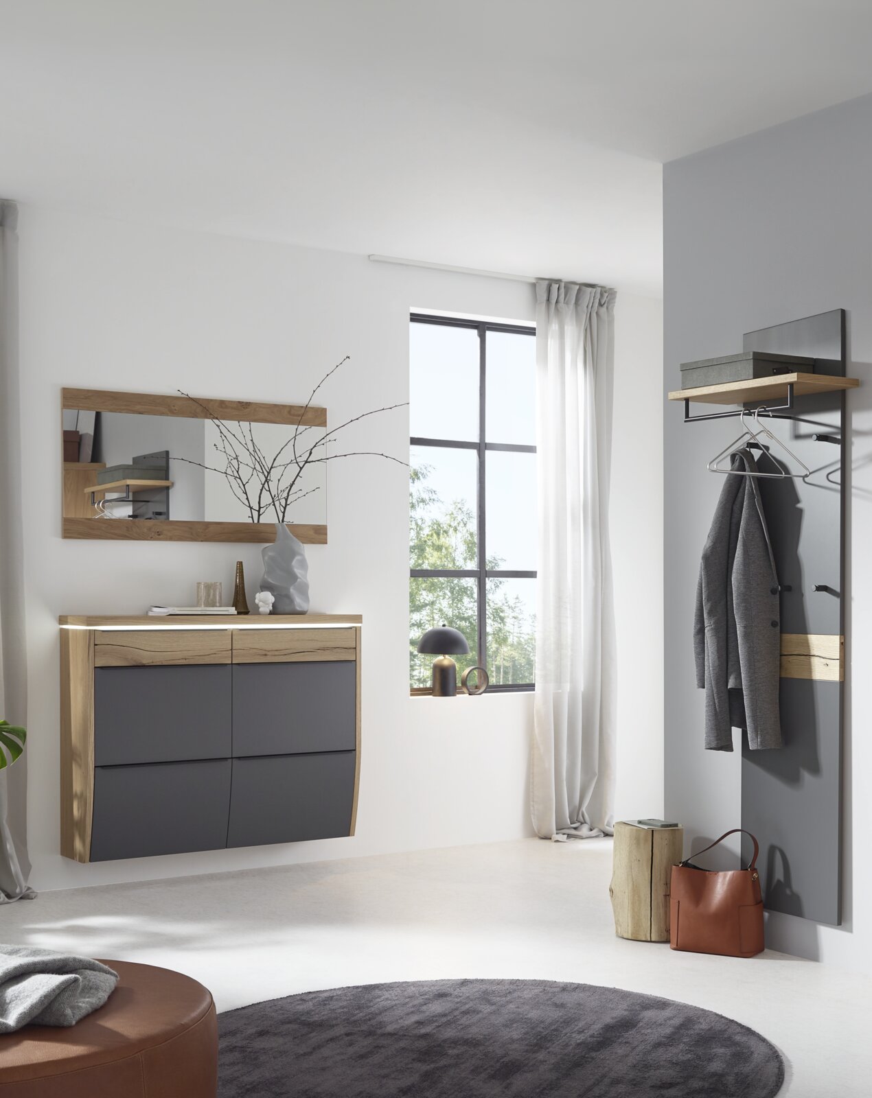 Dieter Knoll Garderoben-Set 4-tlg. ARCO TREND Modernes Flur-Set mit wandhängender Kommode in Holzoptik und anthrazitfarbenen Fronten, passendem Spiegel sowie Garderobenpaneel mit Ablage und Kleiderbügeln, frontal aus leicht seitlicher Perspektive im hellen Eingangsbereich.
